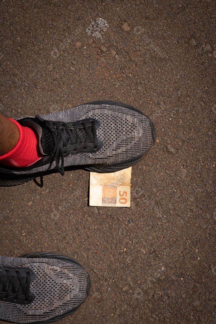 Pisando no dinheiro brasileiro. Imagem do conceito da economia brasileira.