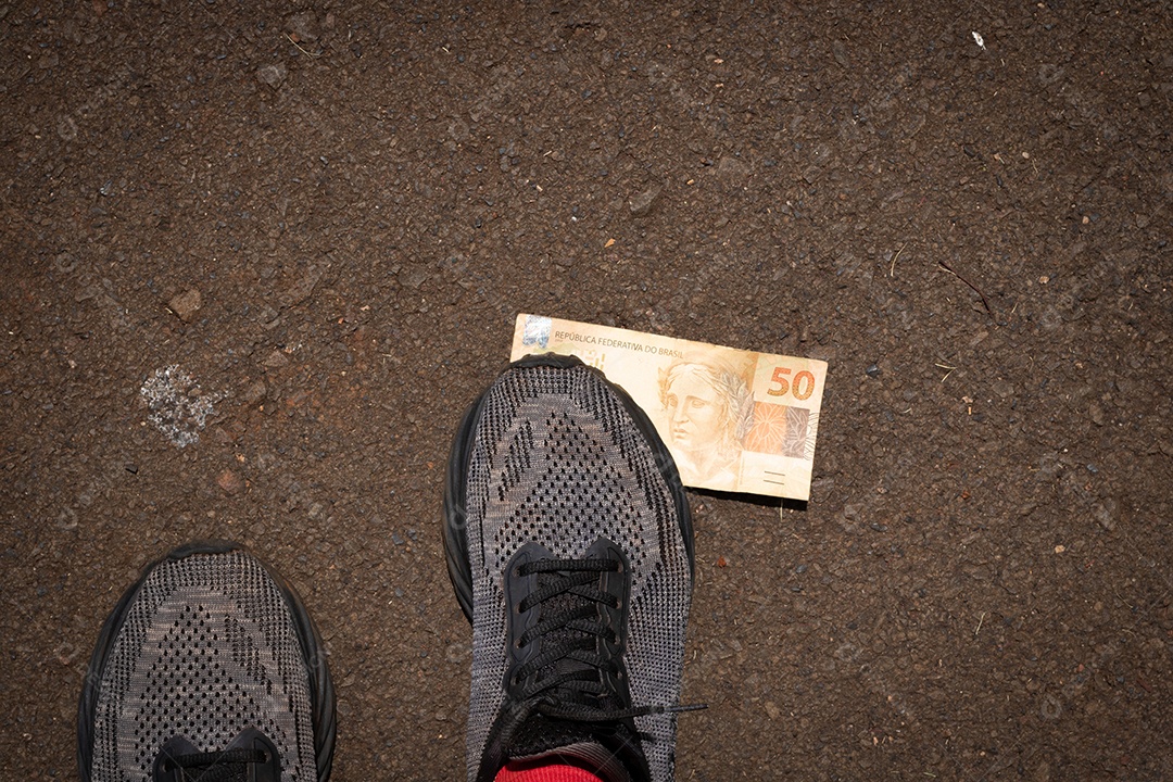 Pisando no dinheiro brasileiro. Imagem do conceito da economia brasileira.