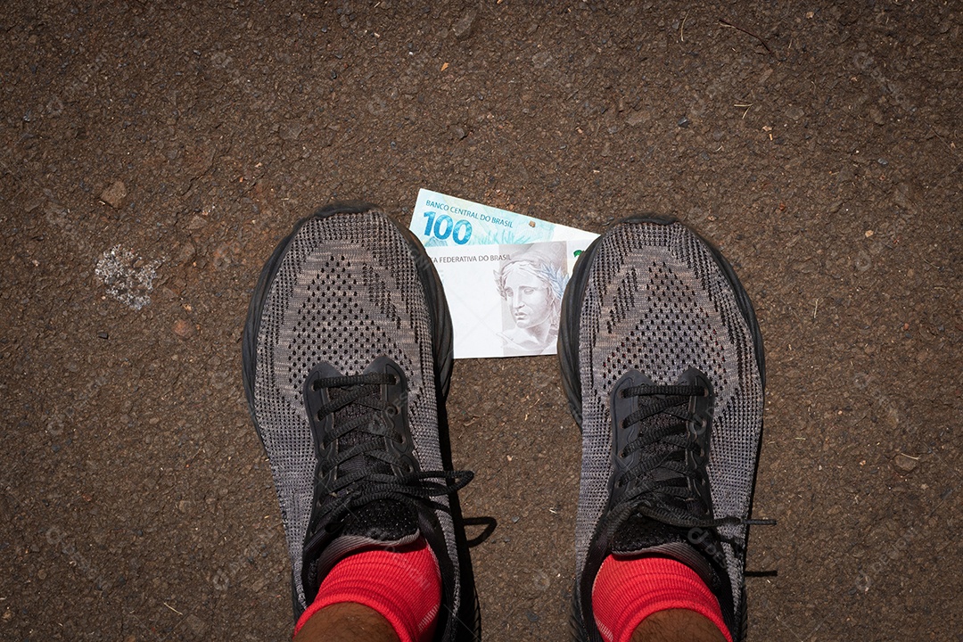 Pisando no dinheiro brasileiro. Imagem do conceito da economia brasileira.