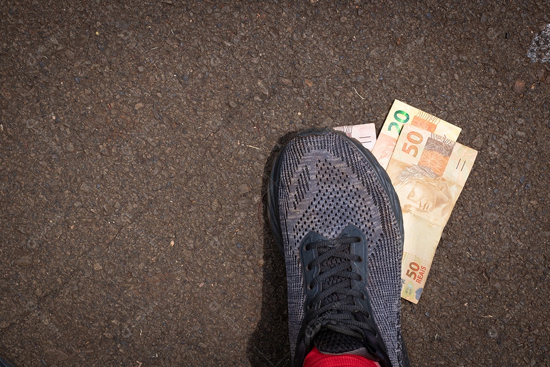Pisando no dinheiro brasileiro. Imagem do conceito da economia brasileira.