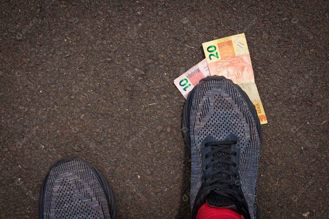 Pisando no dinheiro brasileiro. Imagem do conceito da economia brasileira.