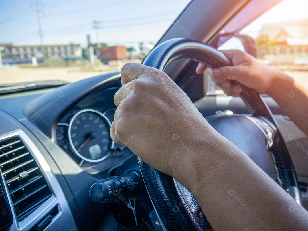 A mão de um homem segurou o volante de um carro para dirigir.