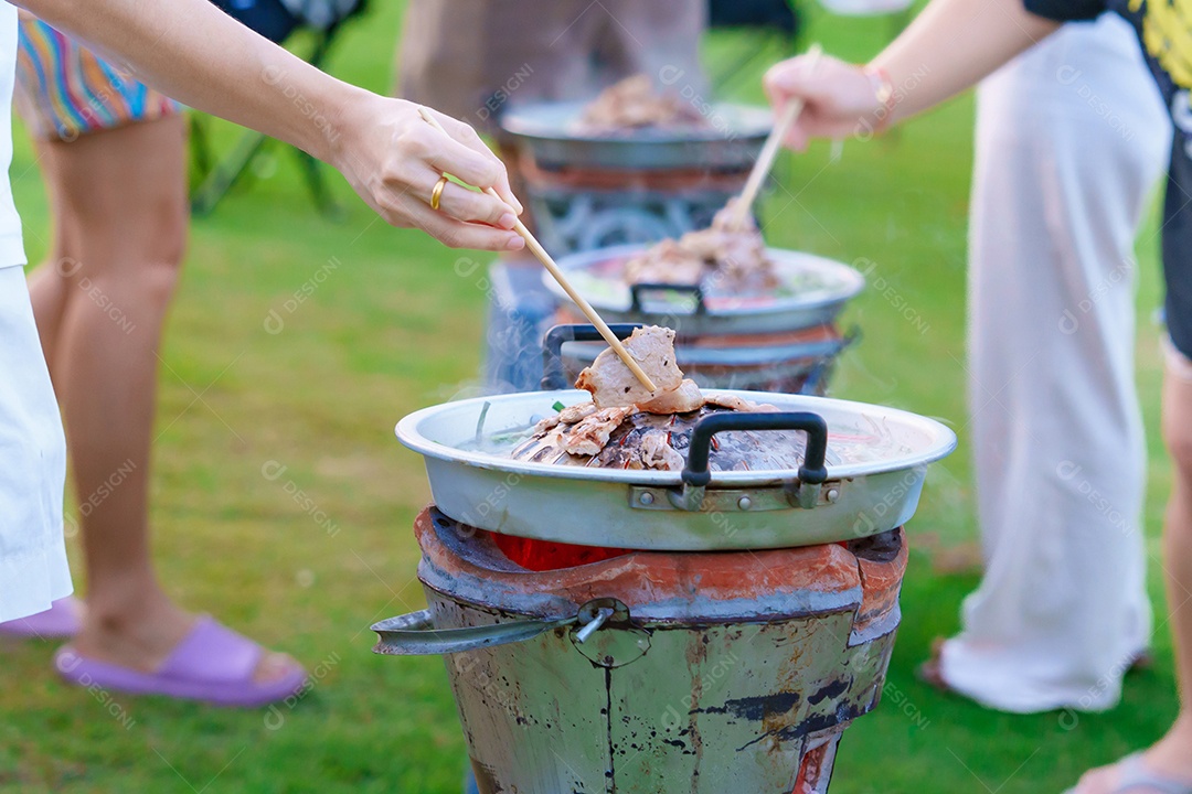 Carne de porco grelhada à mão ou com legumes e sopa na frigideira quente, festa de grupo de amigos e gangue contra a natureza ao ar livre. O estilo tradicional de churrasco tailandês é famoso na Tailândia