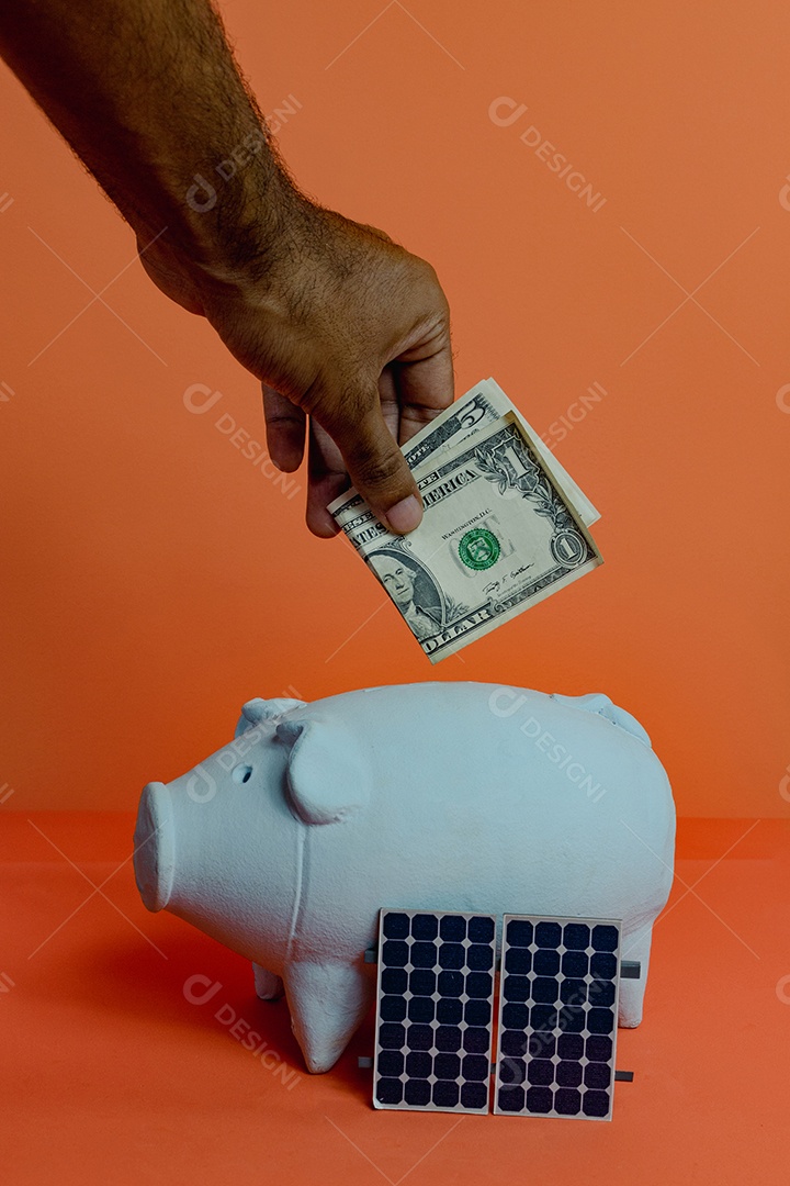 Cofrinho com nota de dólar e painel solar fotovoltaico isolado em fundo laranja. Imagem do conceito de energia solar.