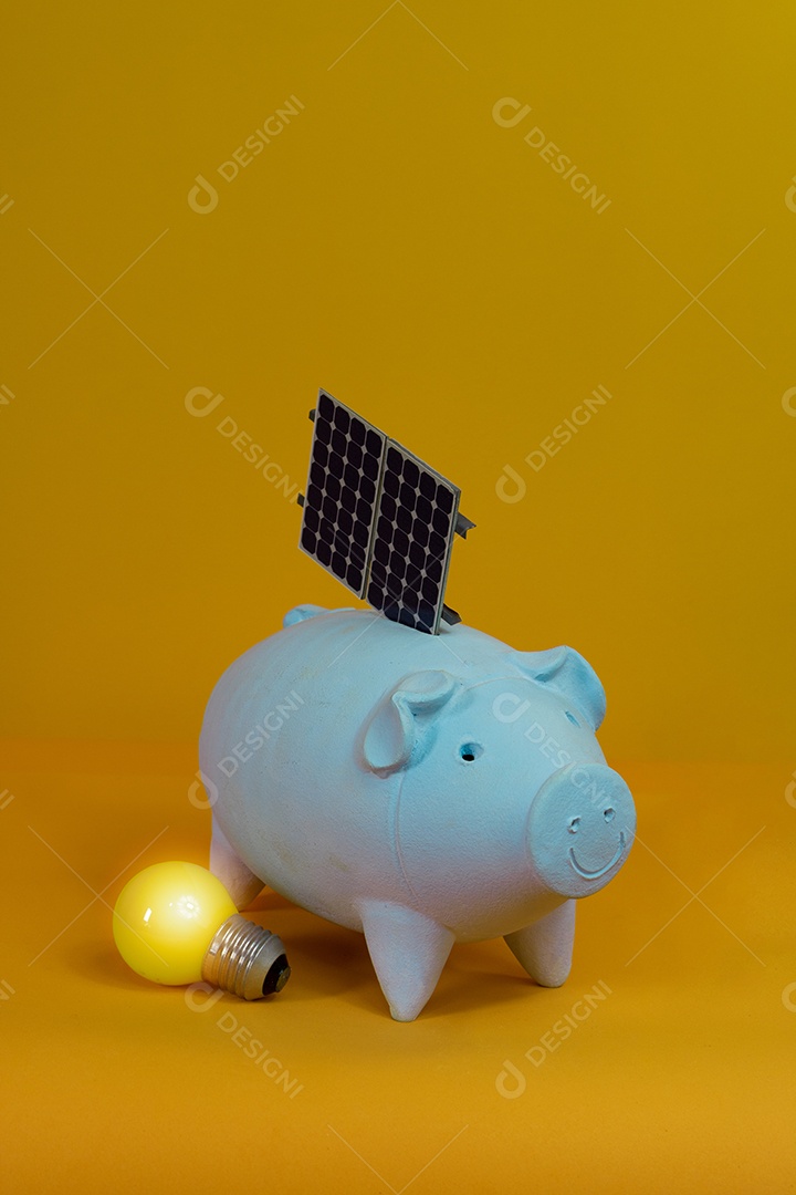 Cofrinho, lâmpada amarela e painel de energia solar fotovoltaica isolado em fundo amarelo.