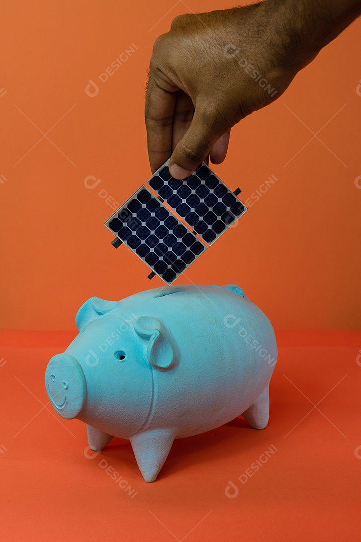 Colocando painel solar fotovoltaico no cofrinho isolado em fundo laranja.