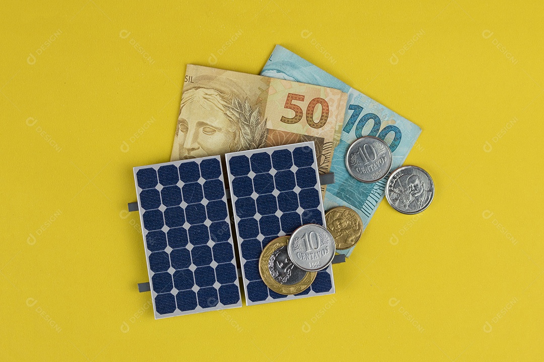 Painel fotovoltaico, dinheiro e fio de tomada isolado em fundo amarelo. painel olar com valores variados de moeda brasileira. Conceito alternativo de negócios de energia limpa.