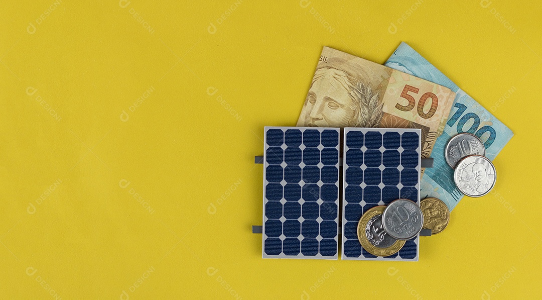 Painel fotovoltaico, dinheiro e fio de tomada isolado em fundo amarelo. painel olar com valores variados de moeda brasileira. Conceito alternativo de negócios de energia limpa.