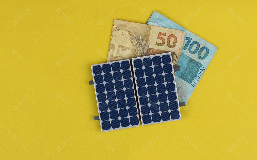 Painel fotovoltaico, dinheiro e fio de tomada isolado em fundo amarelo. painel olar com valores variados de moeda brasileira. Conceito alternativo de negócios de energia limpa.