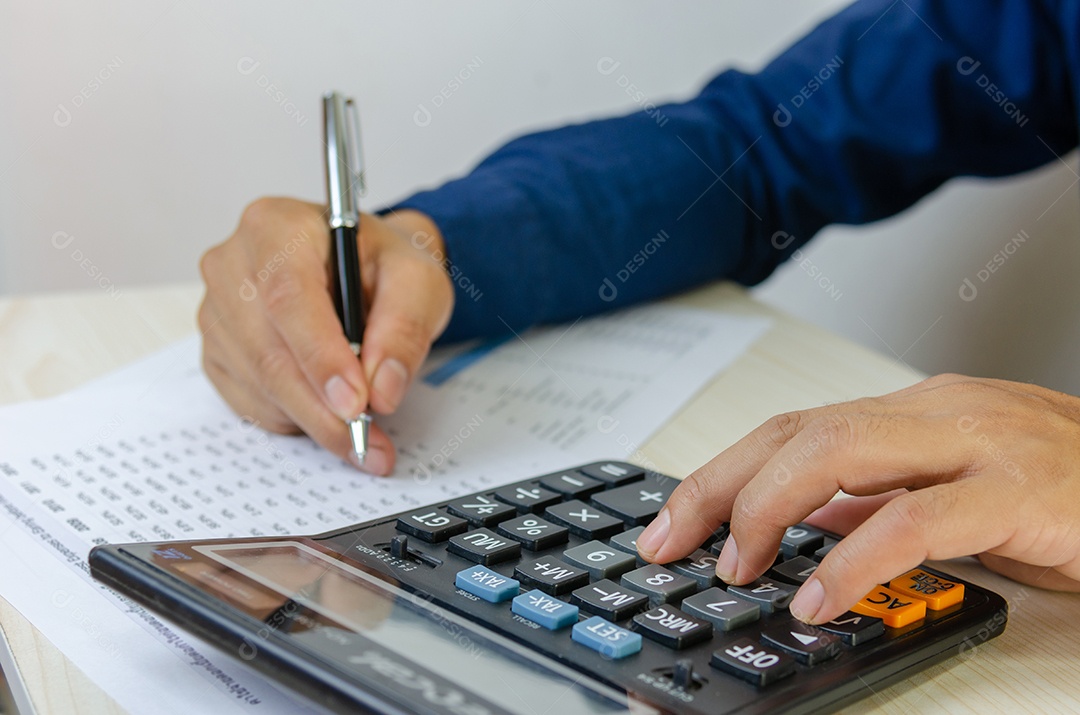 Mão usando a calculadora e escrevendo anota o contador trabalhando na mesa
