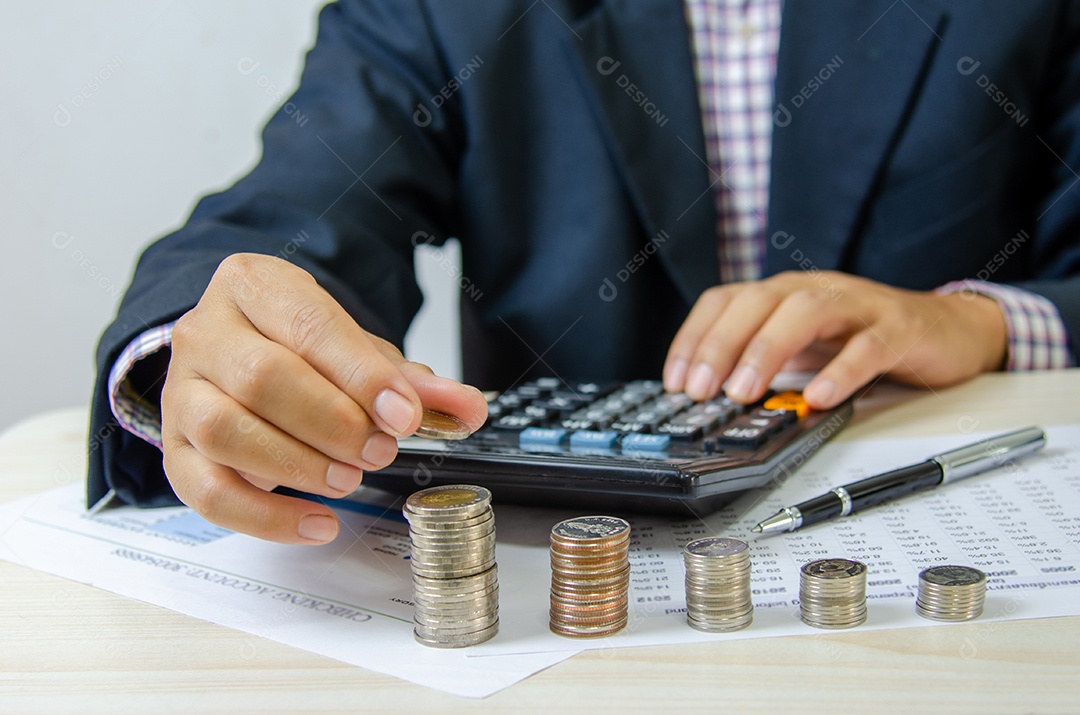 Empresário, segurando a pilha de moedas na mesa. Investimento financeiro bancário