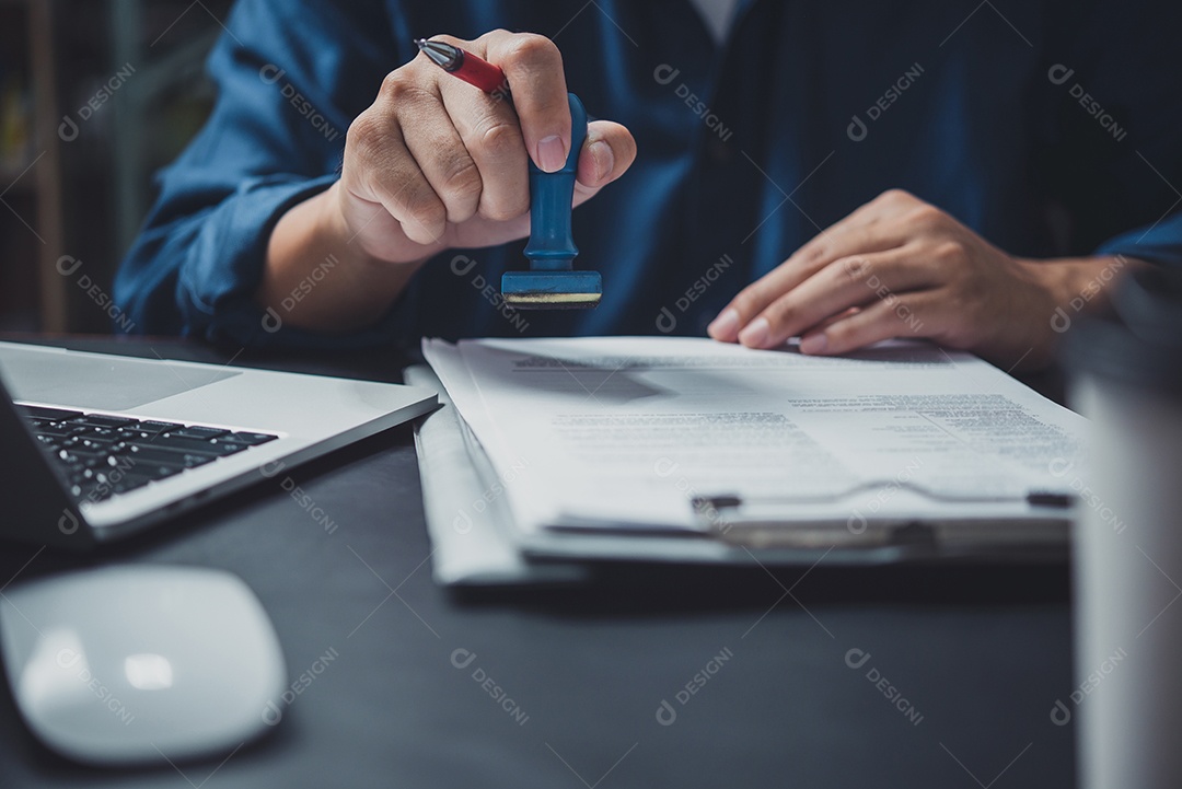 Homem carimbando a aprovação de documentos bancários de finanças de trabalho