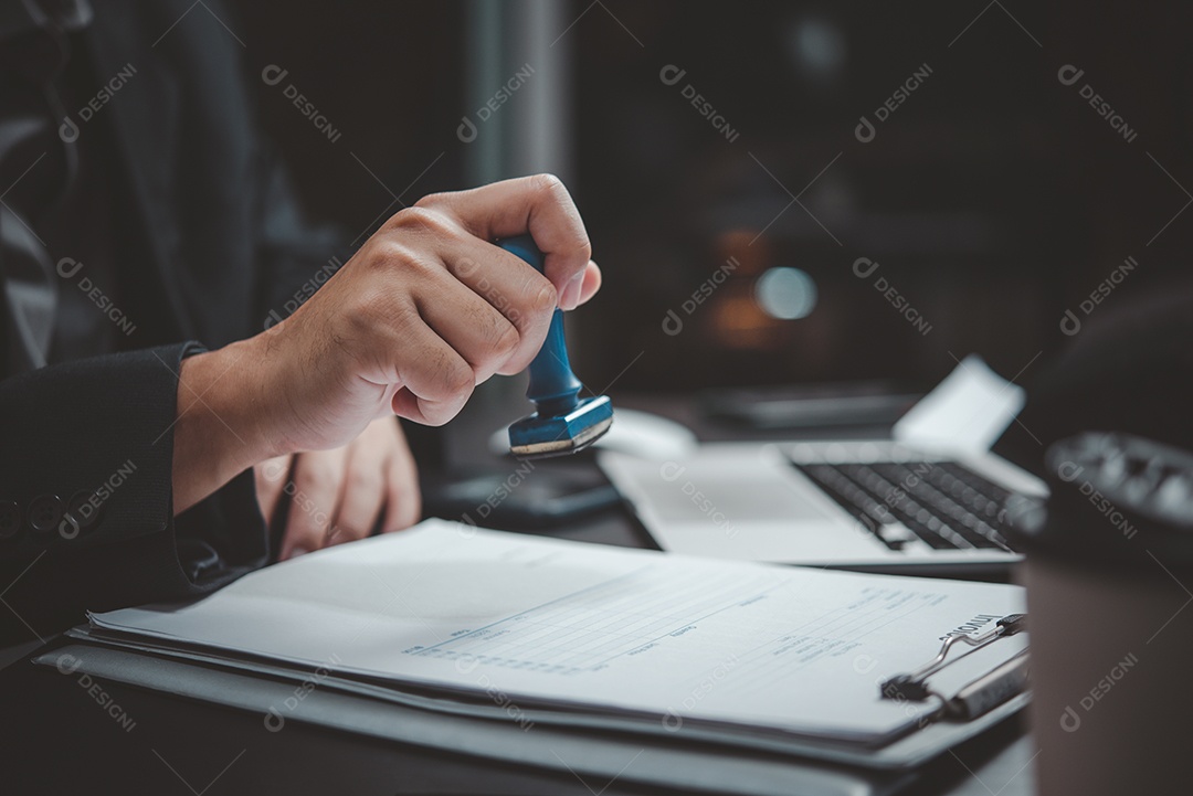 Homem carimbando a aprovação de documentos bancários de finanças de trabalho