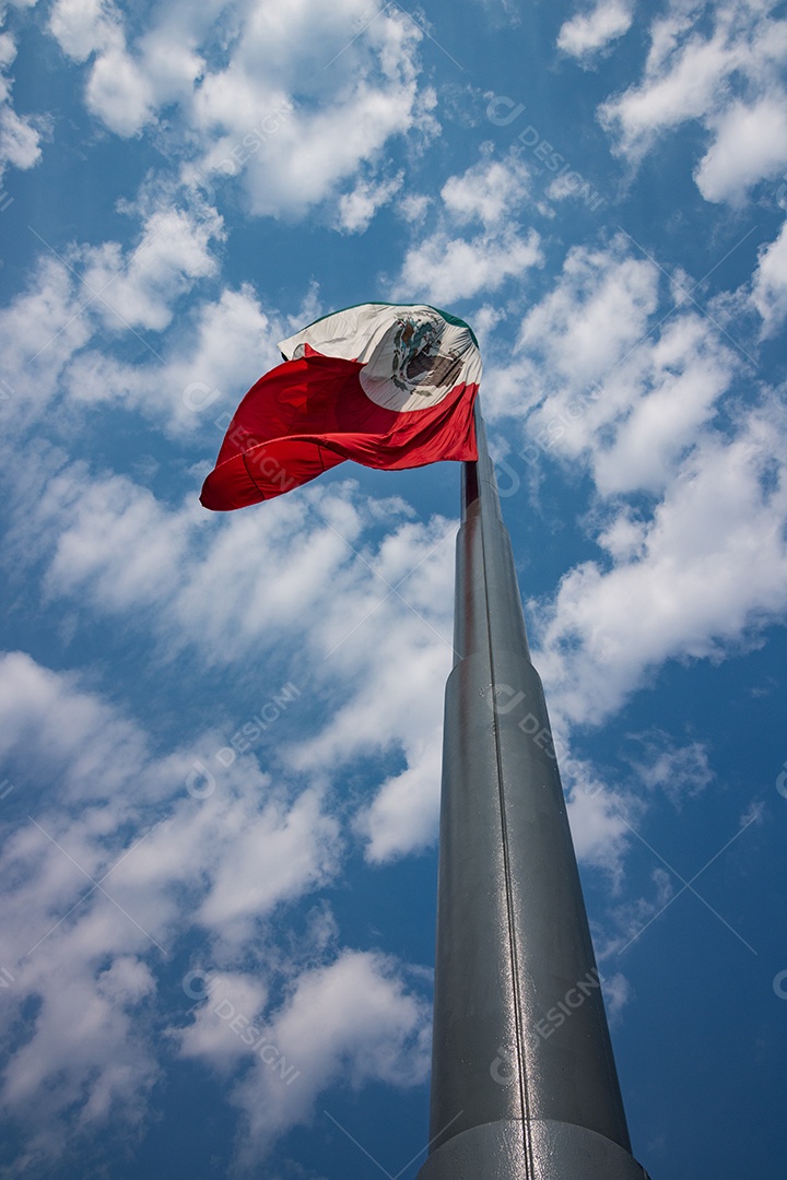 Bandeira mexicana tremulando sobre um céu nublado.