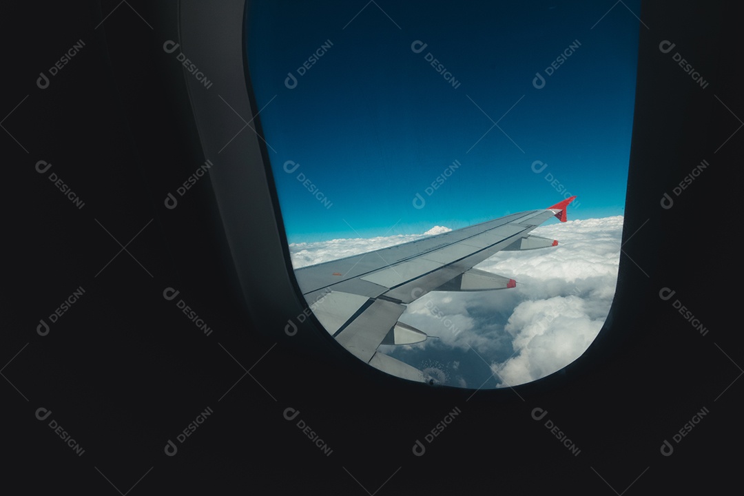 Avião de janela de exibição de viagem com montanhas e nuvens ao fundo.