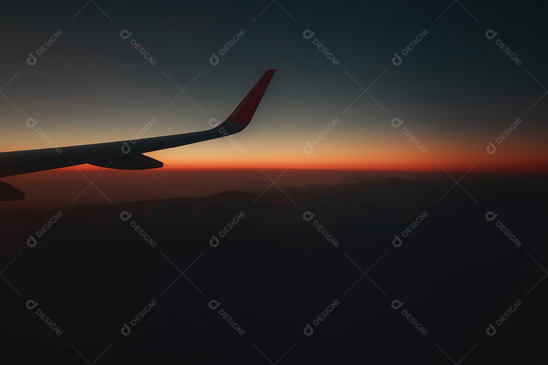 Avião de janela de exibição de viagem com montanhas e nuvens ao fundo.