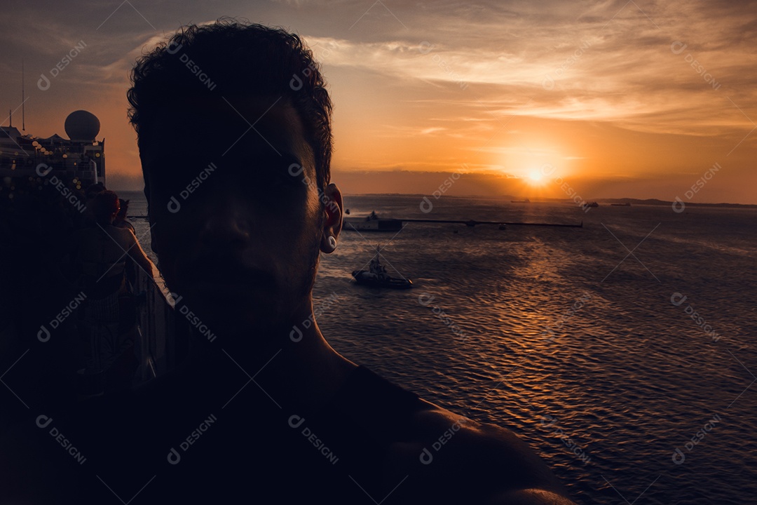 Silhueta de um homem em cruzeiro ao pôr do sol no mar no Brasil