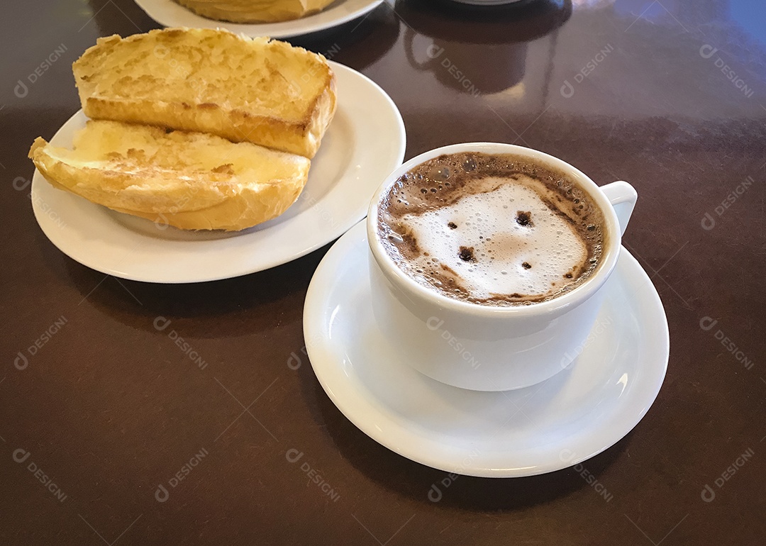 Pão torrado com manteiga na chapa e capuccino na mesa de madeira. Café da Manhã