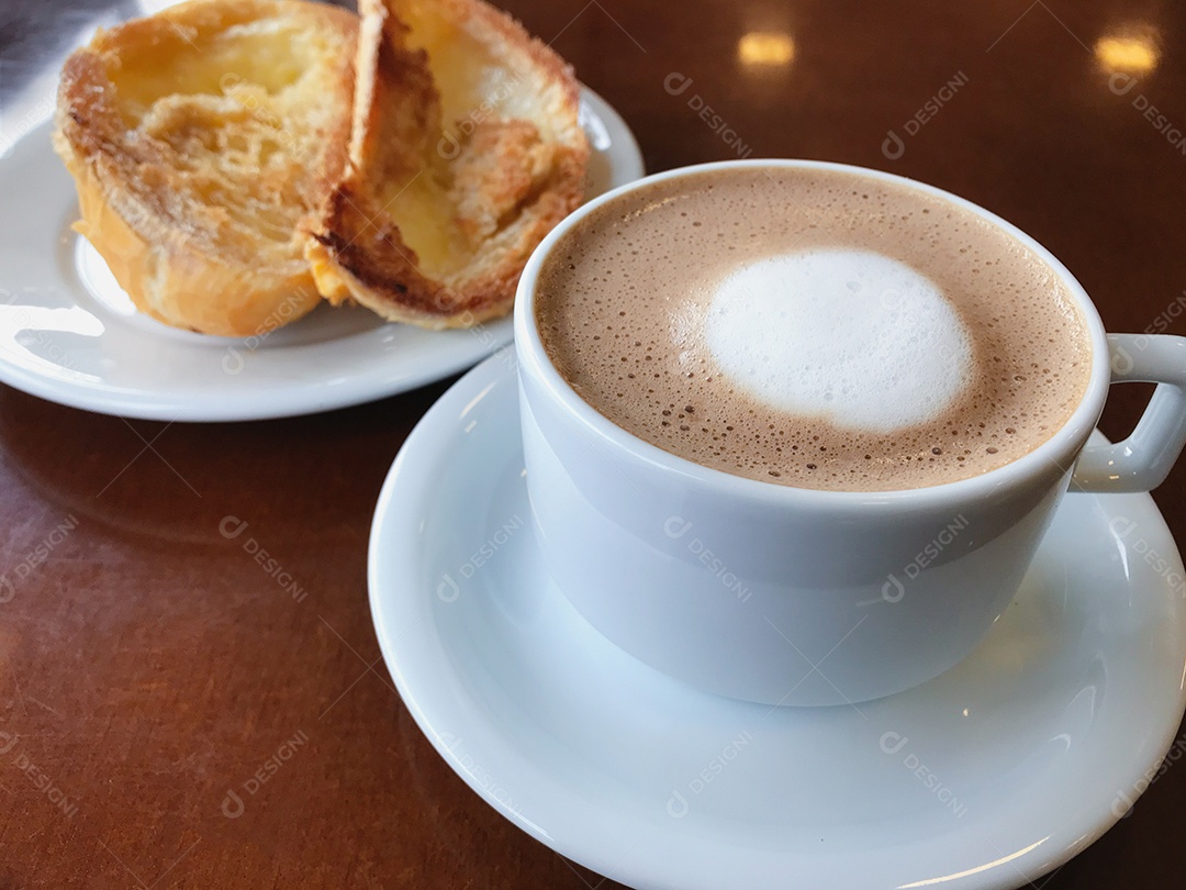 Café da manhã brasileiro. Xícara de capuccino e pão torrado com manteiga
