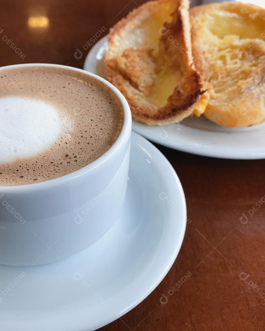 Café da manhã brasileiro. Xícara de capuccino e pão torrado com manteiga