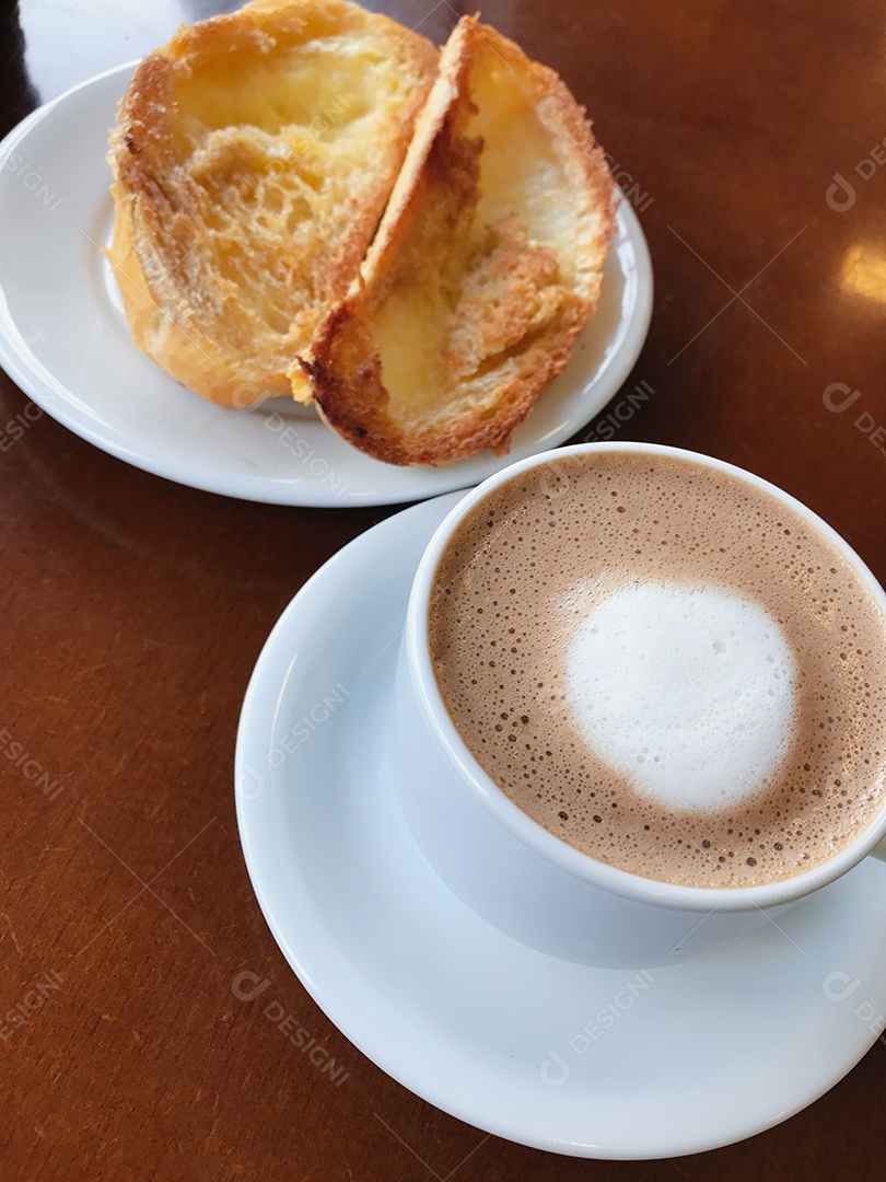 Café da manhã brasileiro. Xícara de capuccino e pão torrado com manteiga