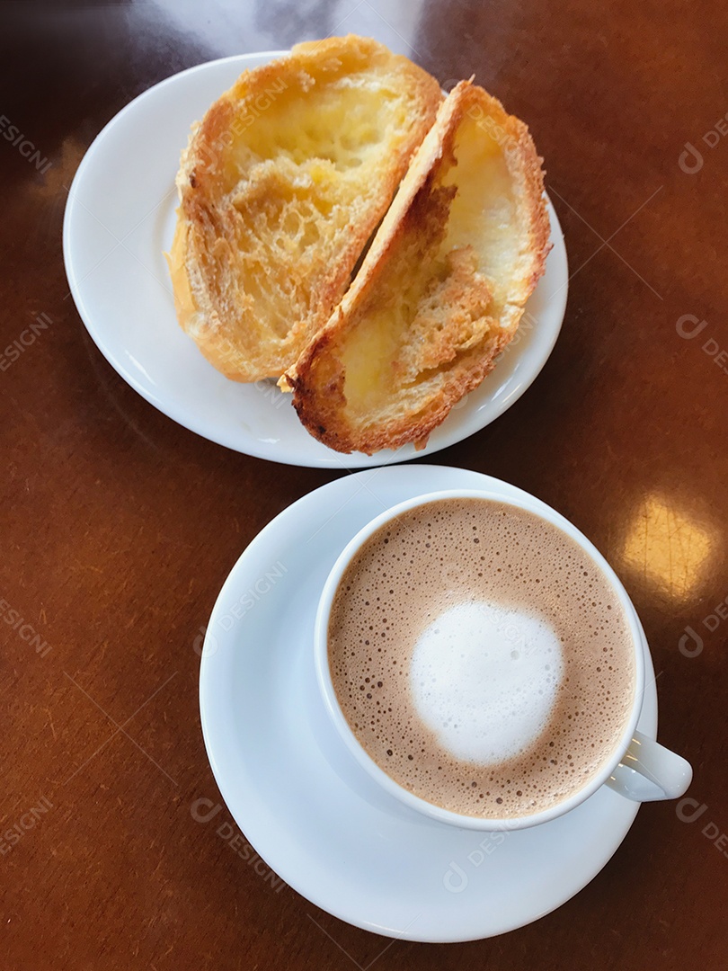 Café da manhã brasileiro. Xícara de capuccino e pão torrado com manteiga