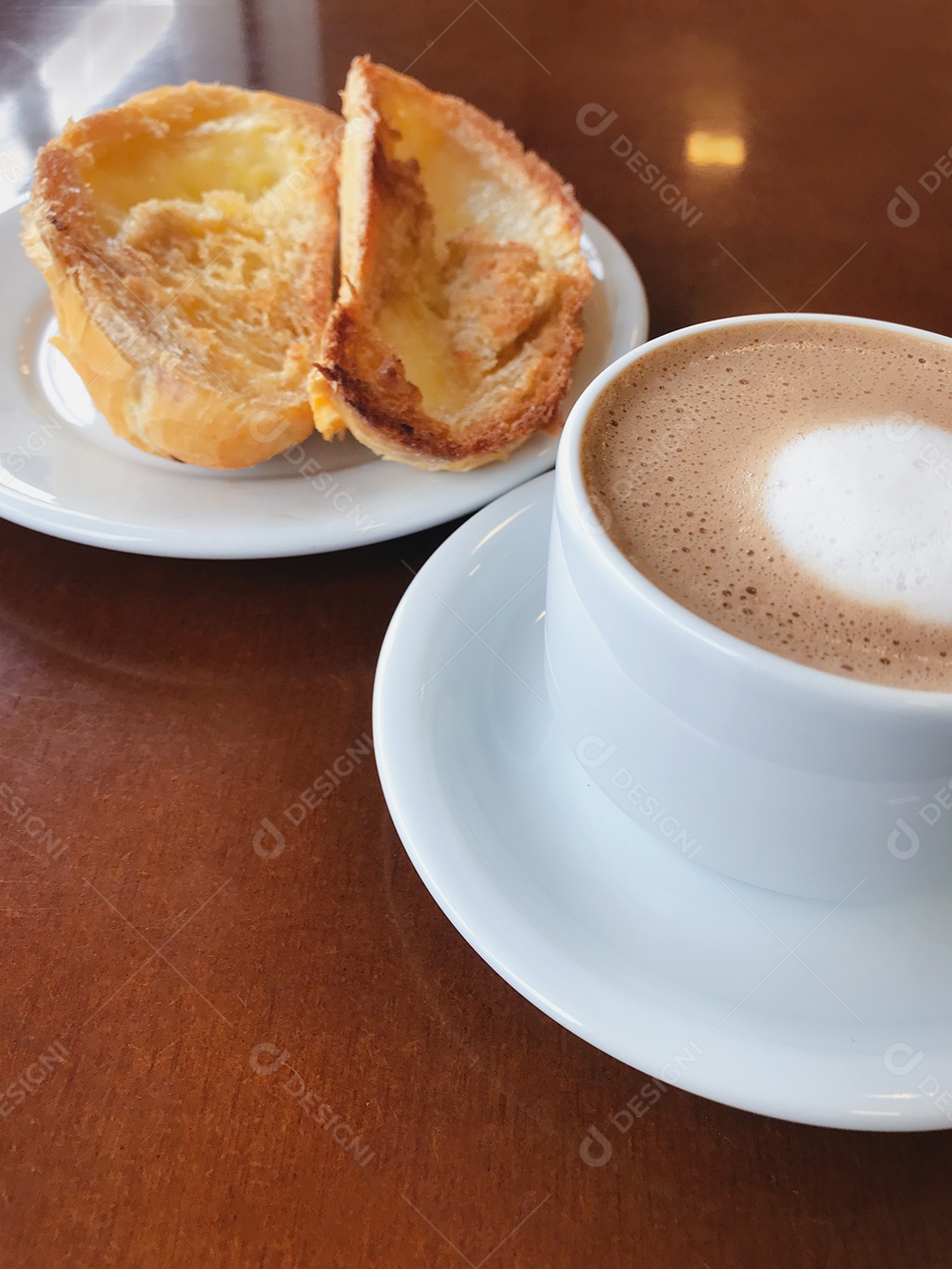 Café da manhã brasileiro. Xícara de capuccino e pão torrado com manteiga