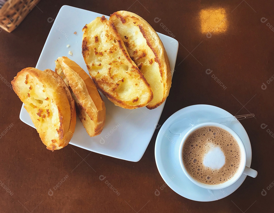 Café da manhã brasileiro. Xícara de capuccino e pão torrado com manteiga