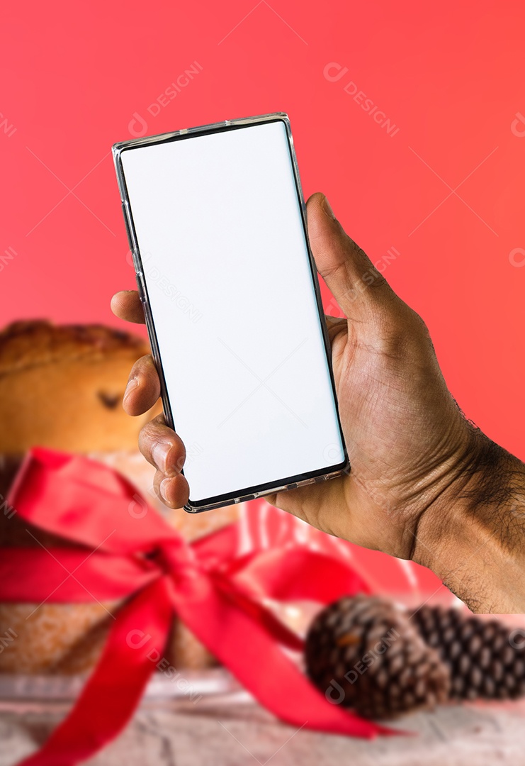 Segurando um celular em um fundo de Natal. Mãos negras com tela de celular