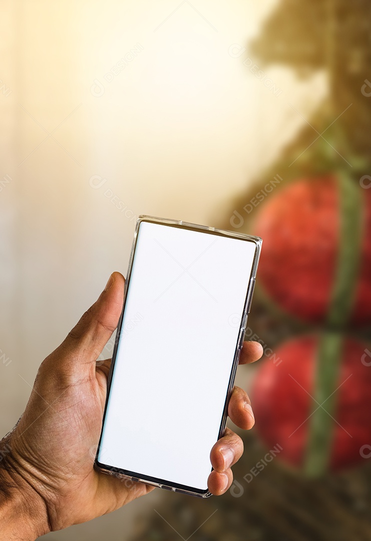 Segurando um celular em um fundo de Natal. Mãos negras com tela de celular