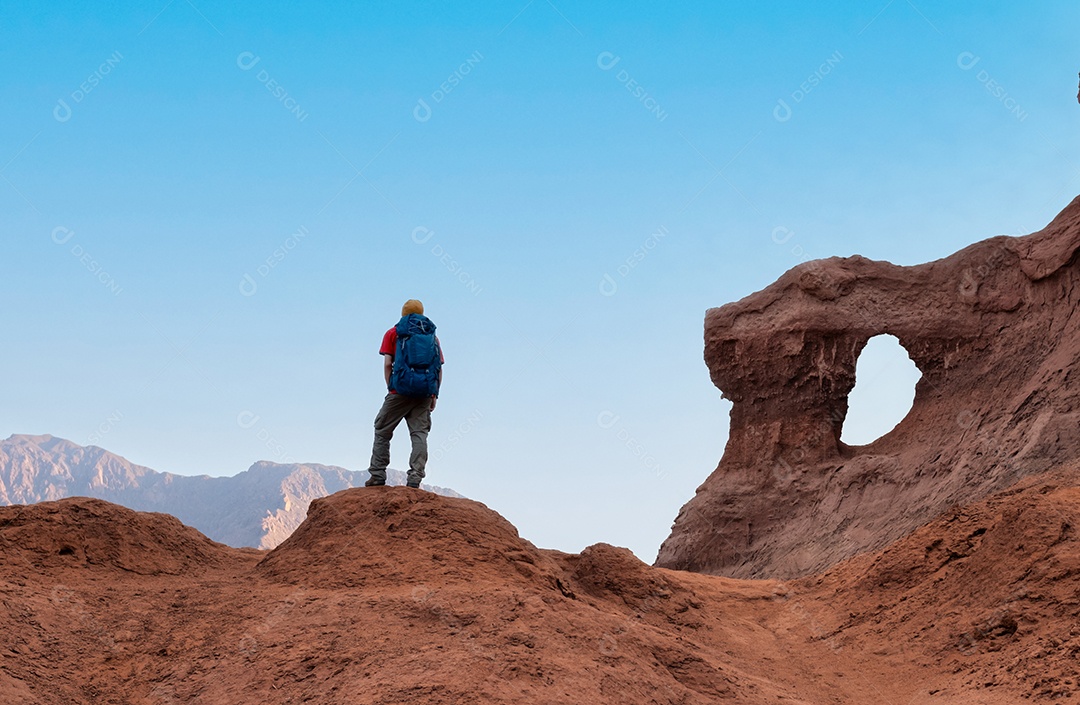 Caminhante com mochila aprecia a paisagem nas montanhas desertas