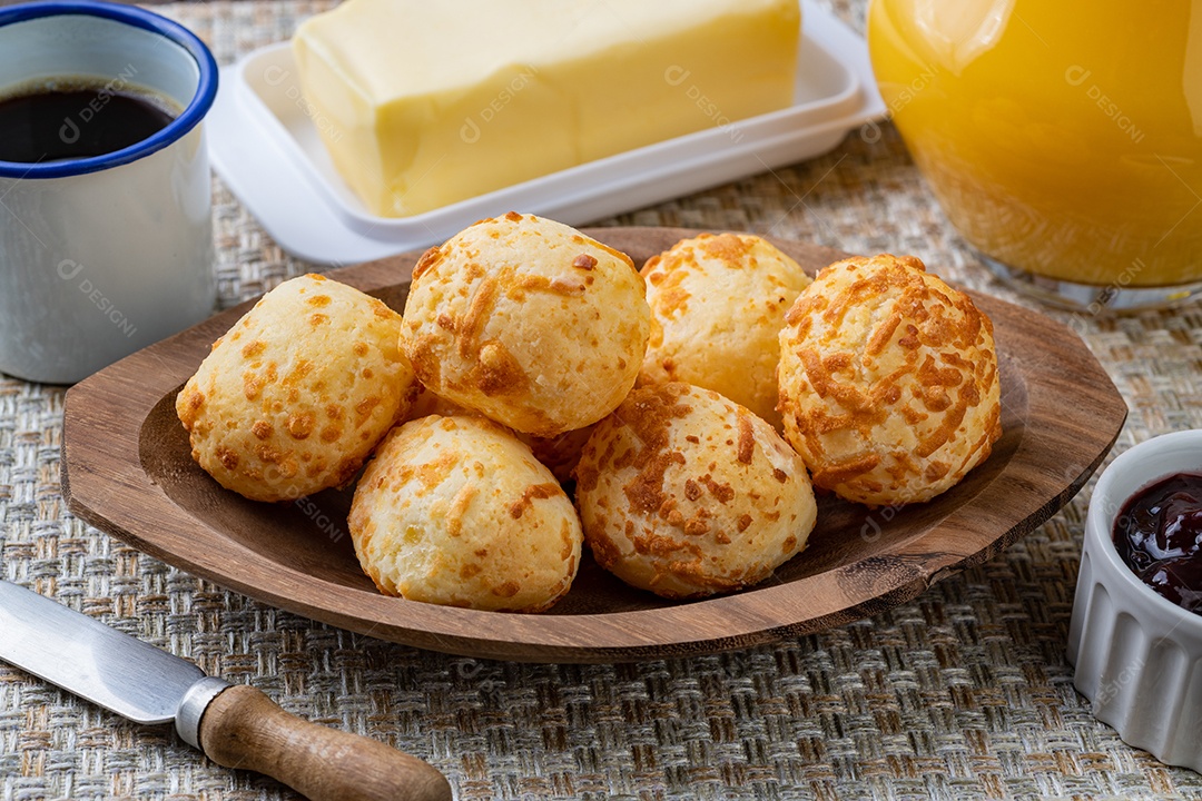 Pão de queijo brasileiro típico em um prato com café, manteiga