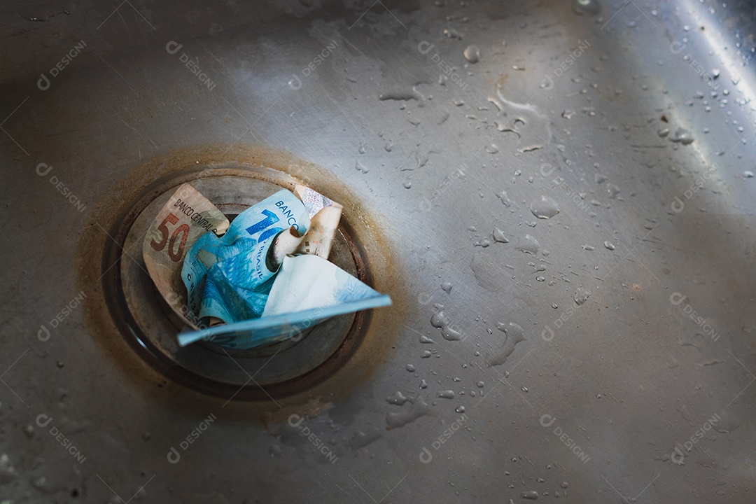 dinheiro jogado no ralo da pia cinza