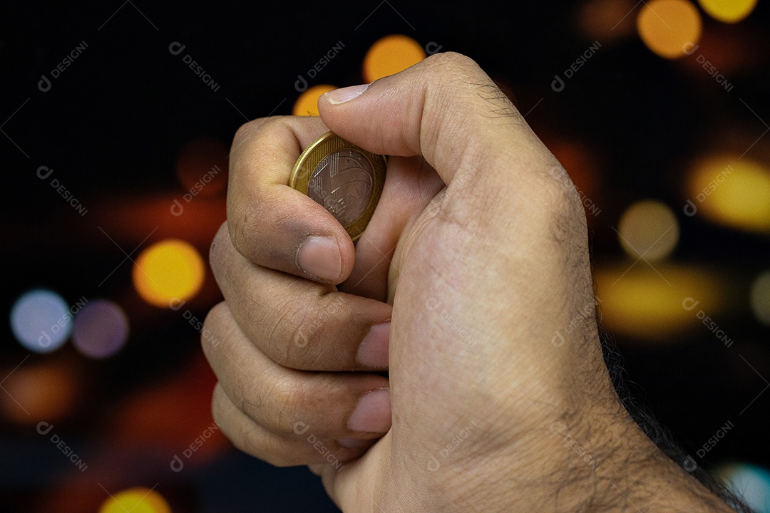 Segurando uma moeda brasileira em um fundo desfocado