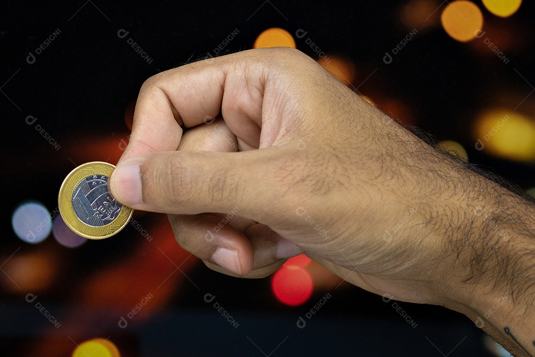 Segurando uma moeda brasileira em um fundo desfocado