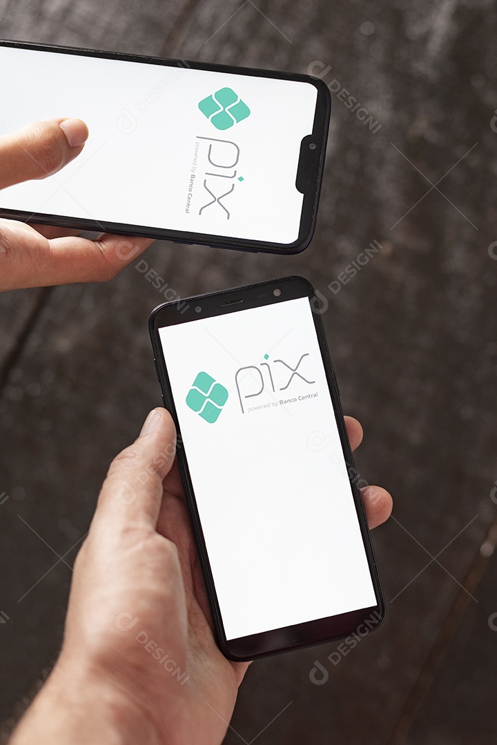 Mãos pessoa segurando celulares com logo do pix