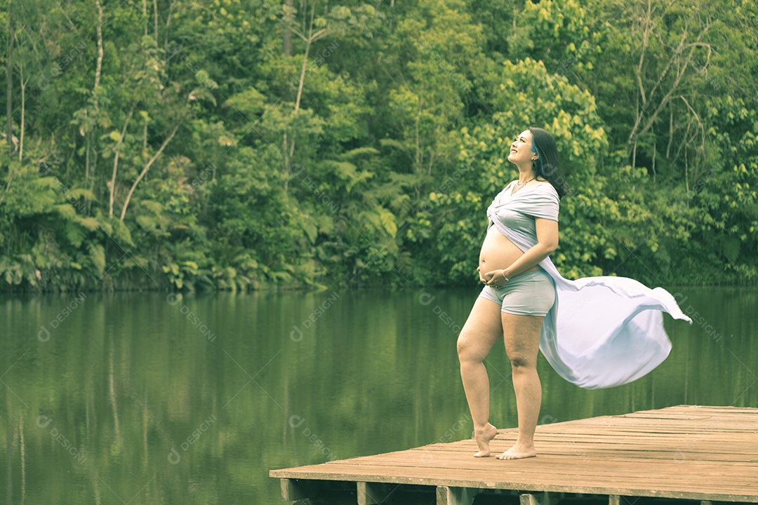 Linda mulher gravida sobre uma linda paisagem