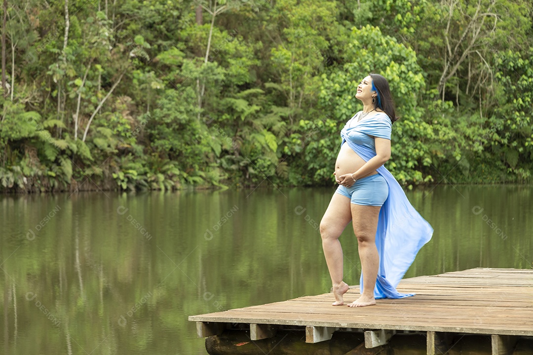 Linda mulher gravida sobre uma linda paisagem