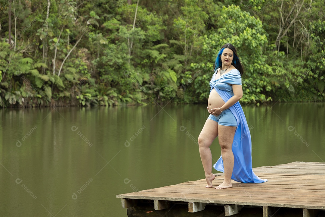 Linda mulher gravida sobre uma linda paisagem