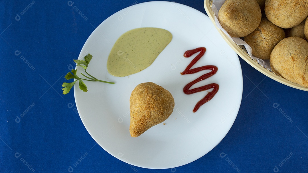 Coxinha frita sobre um prato branco mesa lanchonete