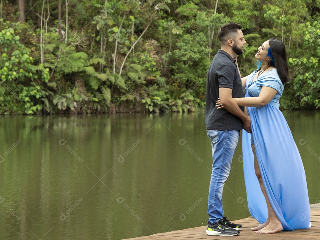 Homem com ao lado de sua esposa gravida sobre linda paisagem