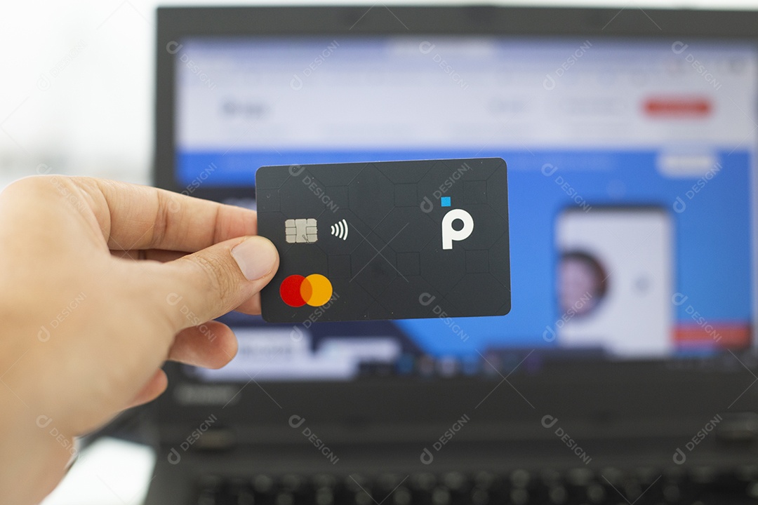 Mãos pessoa segurando cartão de credito sobre fundo notebook