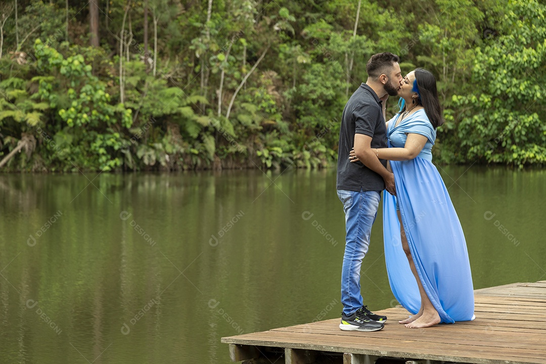 Homem com ao lado de sua esposa gravida sobre linda paisagem