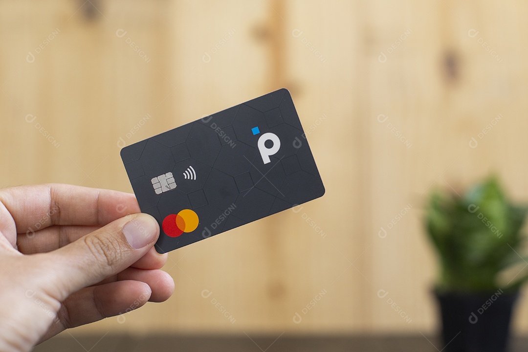 Mãos pessoa segurando cartão de credito sobre mesa madeira