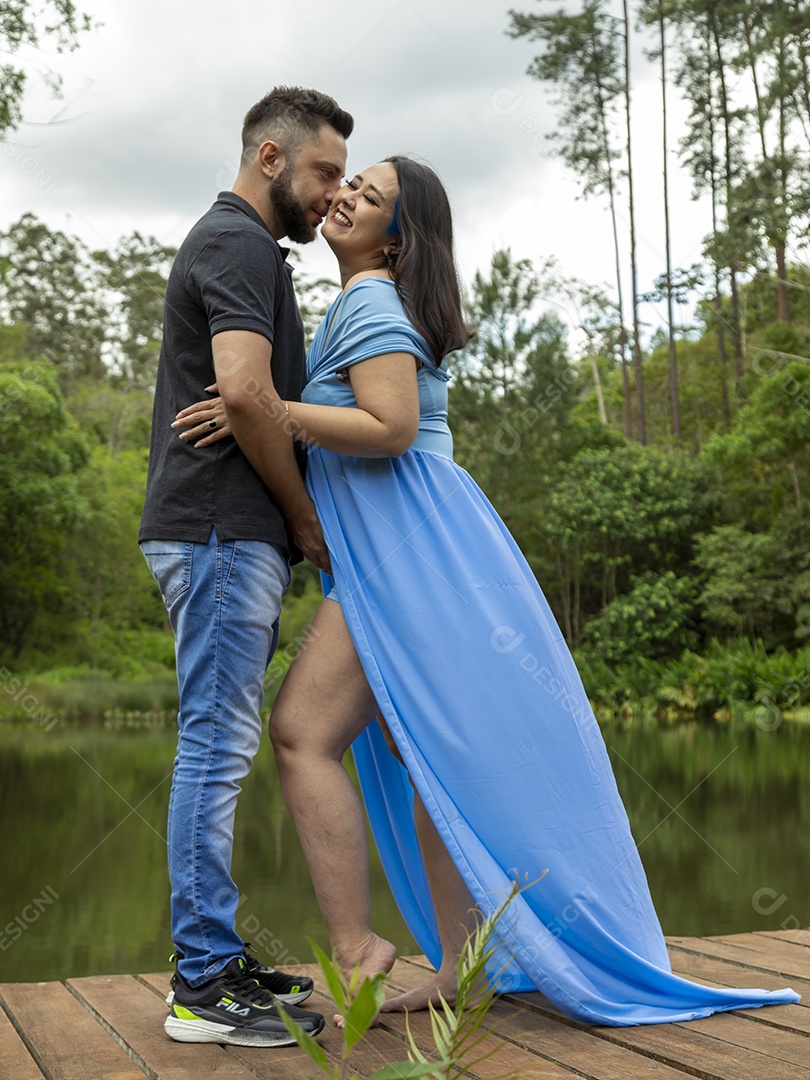 Homem com ao lado de sua esposa gravida sobre linda paisagem