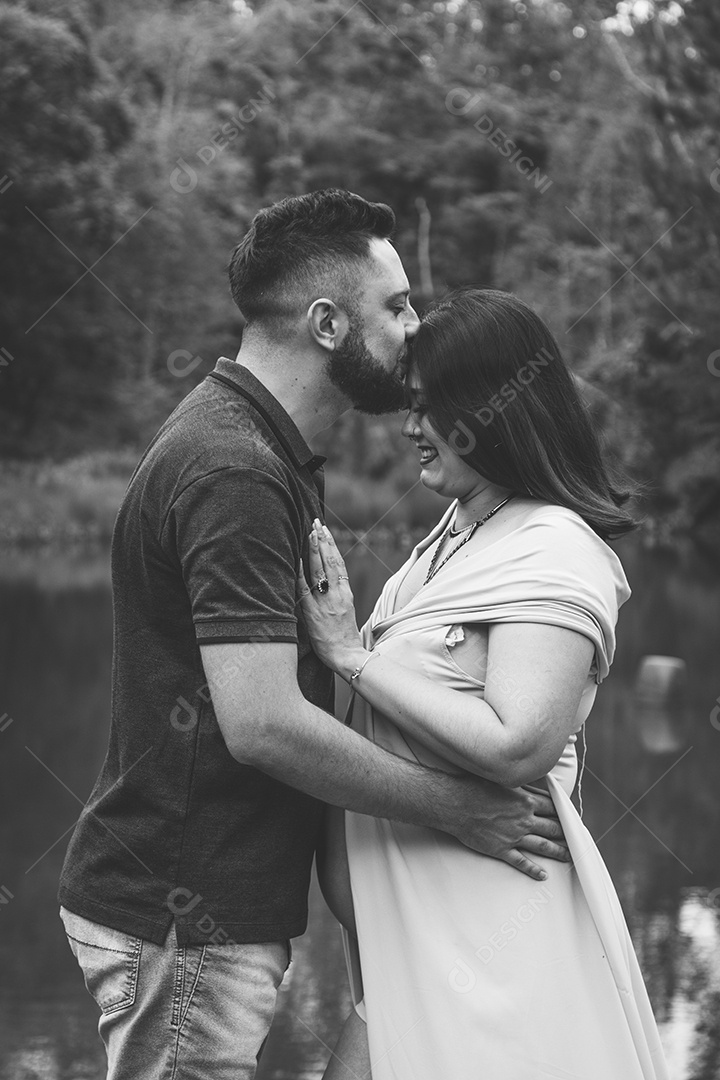 Homem com ao lado de sua esposa gravida sobre linda paisagem