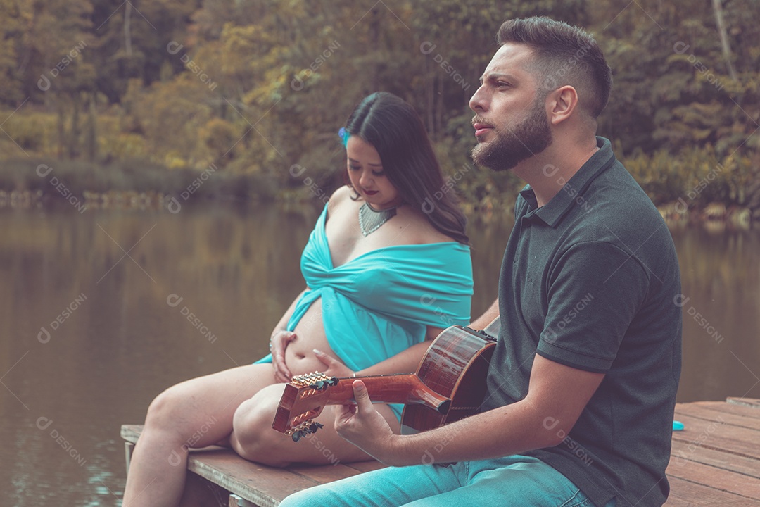 Homem com ao lado de sua esposa gravida sobre um lindo lugar paisagem