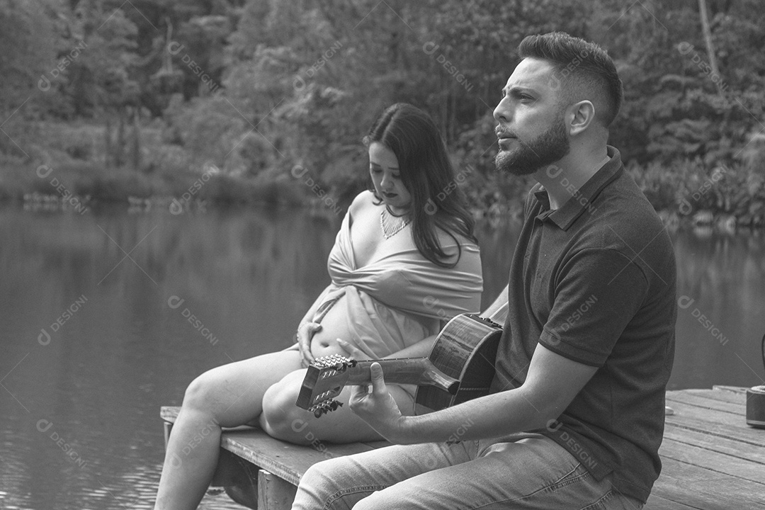 Homem com ao lado de sua esposa gravida sobre um lindo lugar paisagem