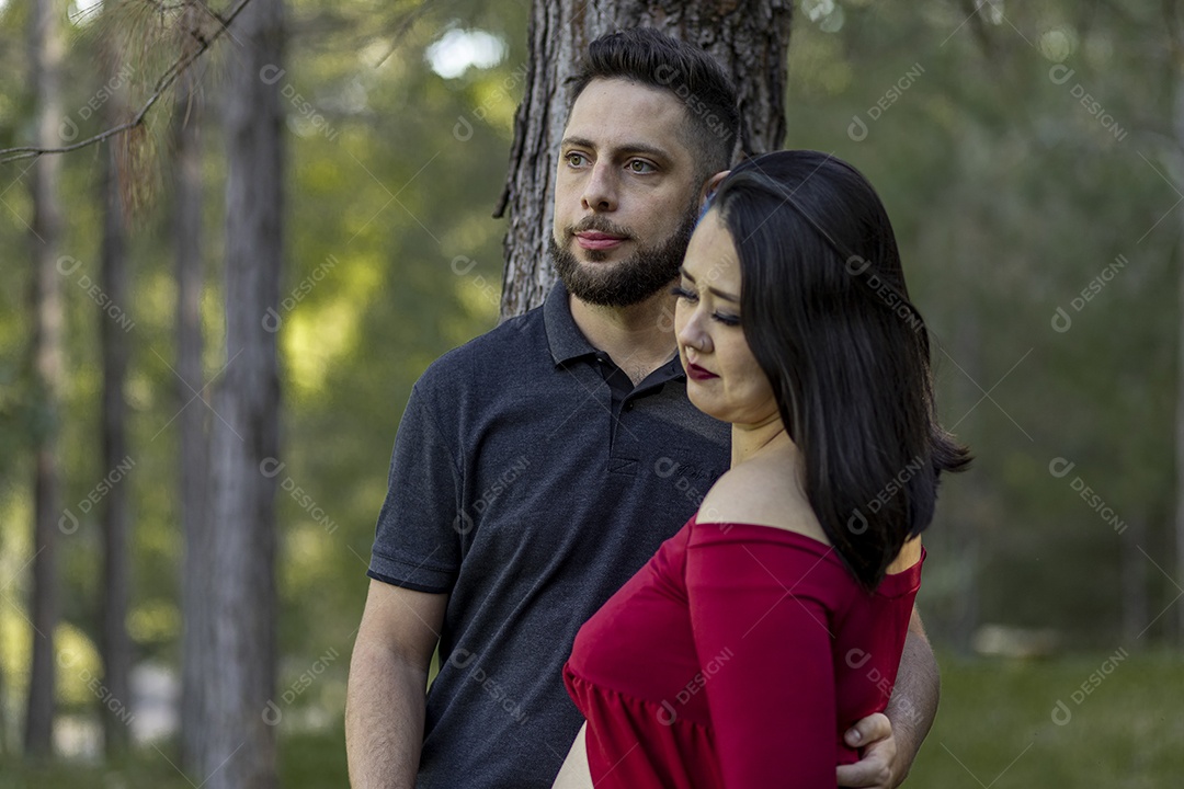 Homem com ao lado de sua esposa gravida sobre um lindo lugar paisagem