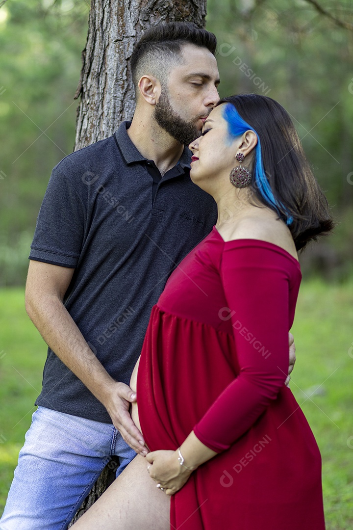 Homem com ao lado de sua esposa gravida sobre um lindo lugar paisagem